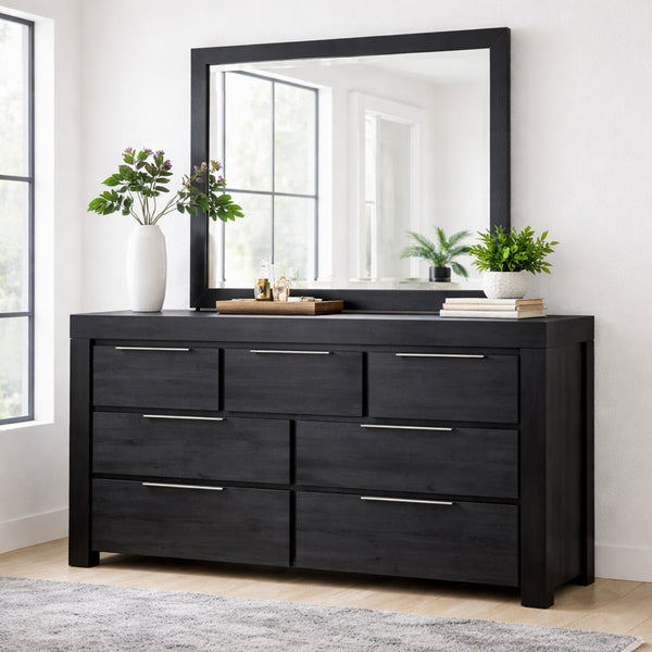 Black dresser with large mirror in a room with plants and decor.