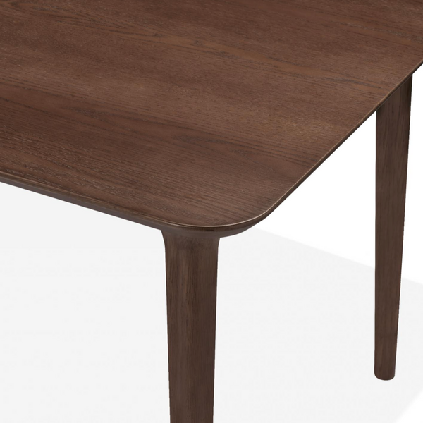 Close-up of a dark brown wooden table showing the tabletop corner with rounded edges and one leg against a white background.