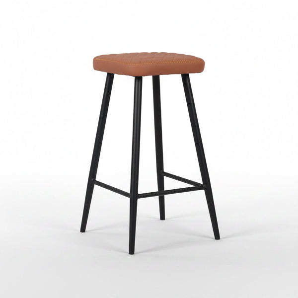 Tan padded bar stool with round seat, tapered black legs, and lower footrest
