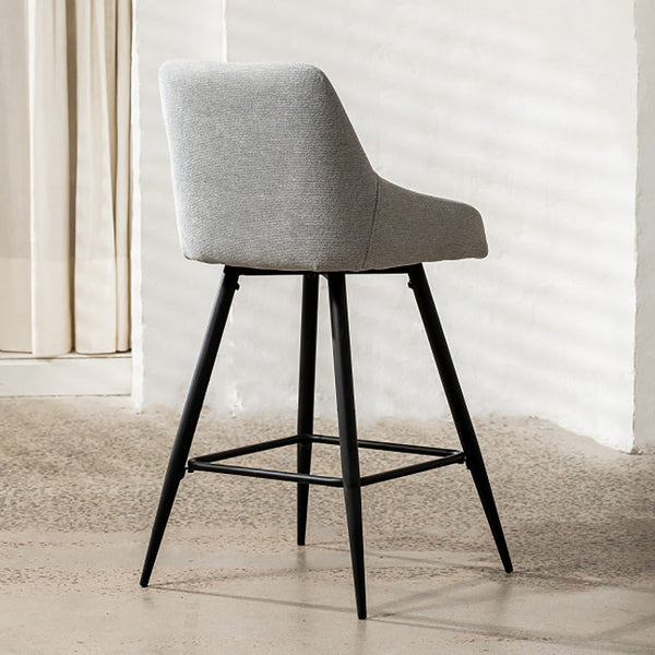 Light grey fabric bar stool with black legs and crossbar footrest, angled