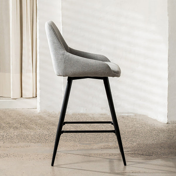 Light grey upholstered bar stool with black frame and footrest, side view