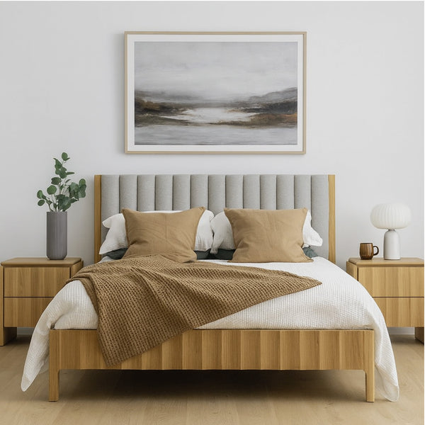 Upholstered light-gray headboard bed with white bedding and tan pillows, light wood frame.