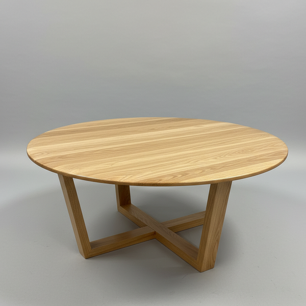 Round light-wood lamp table with X-style support beneath the top