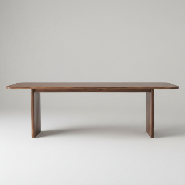 A modern rectangular wooden table with a medium brown finish, featuring fluted pedestal legs, shown against a solid white background.
