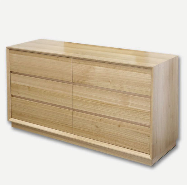 Low wooden dresser with four drawers and sliding panel fronts, light natural oak