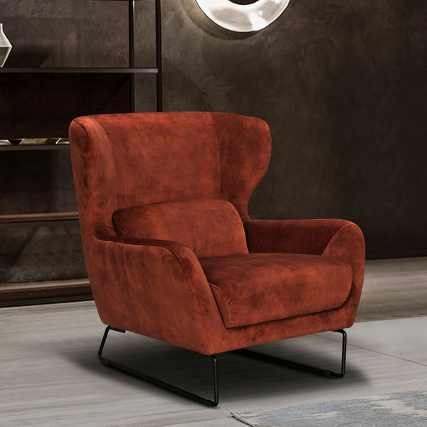 Rust velvet accent chair with rounded arms, low back, and black metal legs