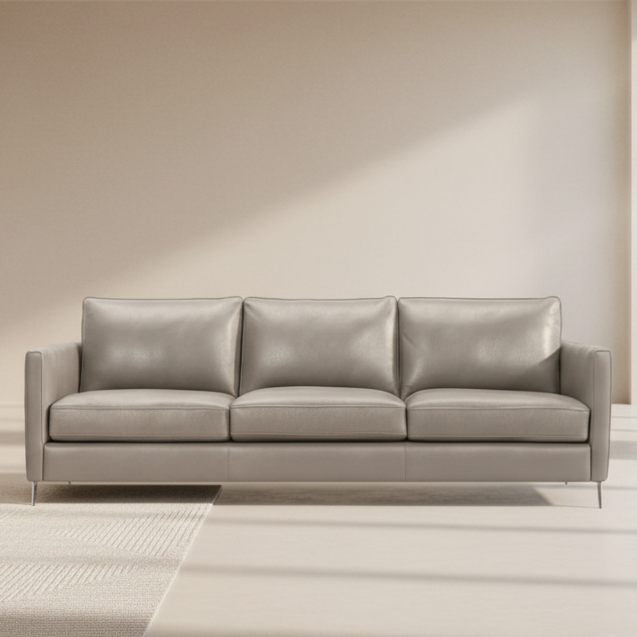 Light-colored leather 3-seat sofa with three padded back cushions and track arms