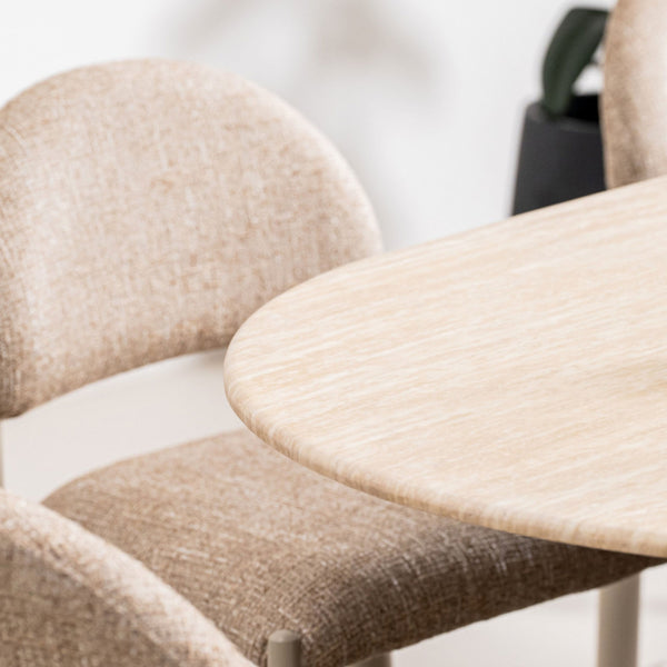 Beige upholstered dining chair with curved arms and light wood legs