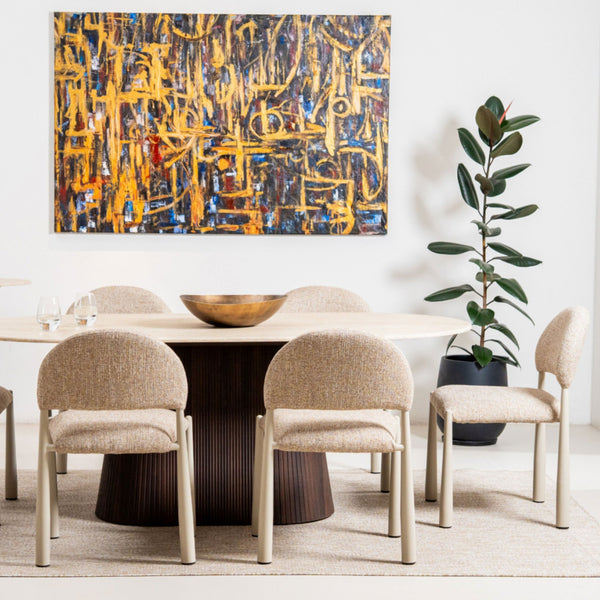 Dining room with a round table and chairs, abstract painting on the wall, and a plant.