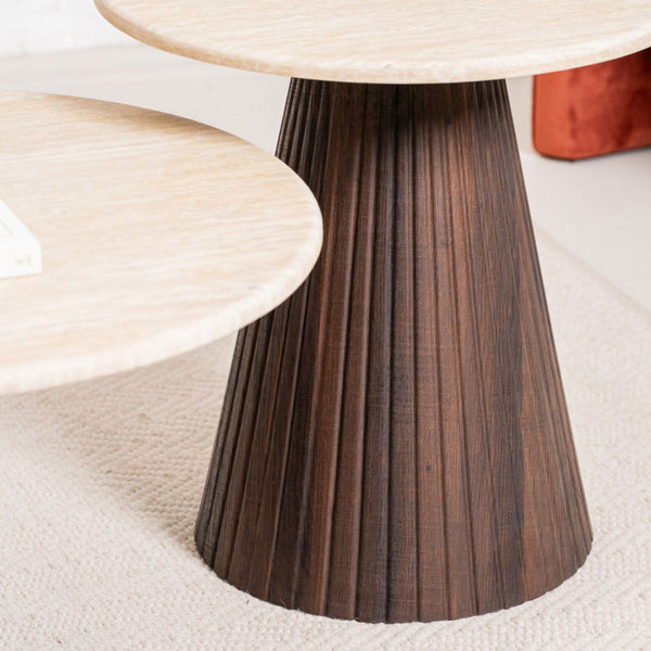Round accent table with dark fluted pedestal base beneath light tabletop