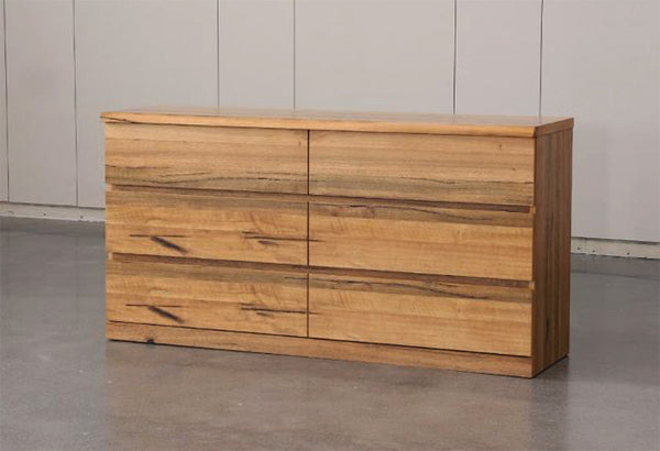 Wooden bedroom dresser with multiple stacked drawer fronts and natural grain finish