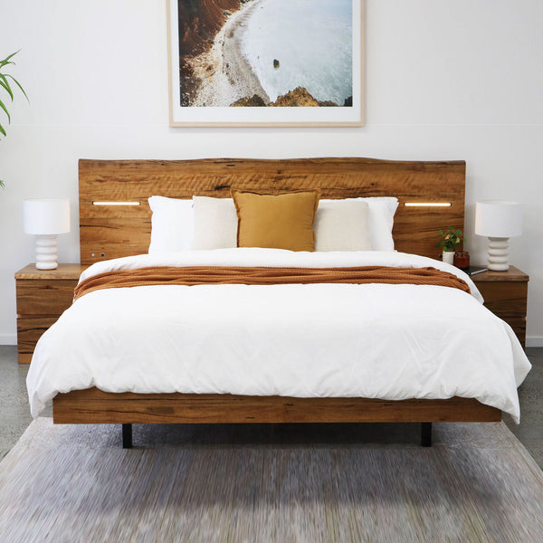 Queen and king size wooden bed frame with slatted headboard, white comforter and pillows