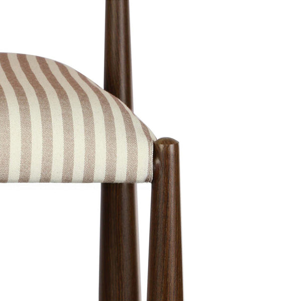 Dining chair arm and leg detail with beige vertical striped fabric cushion on walnut frame