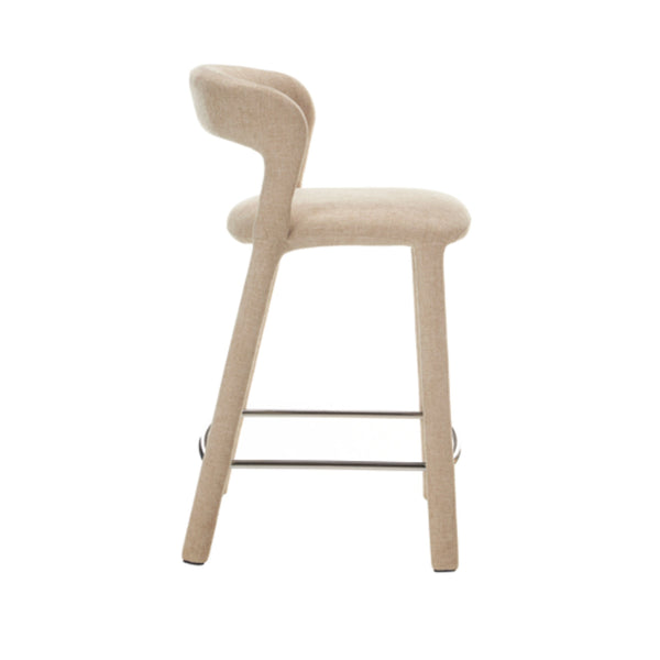 Beige fabric bar stool, side view, padded seat and curved back with metal footrest