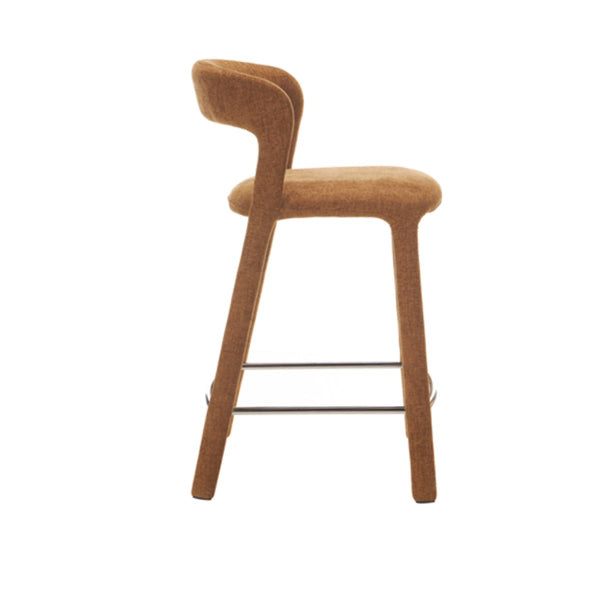 Bar stool side view with copper-toned upholstered seat, curved back, metal footrest