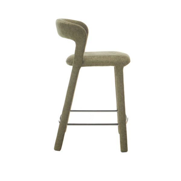 Olive bar stool in fabric with arched backrest and chrome under-seat foot rail.