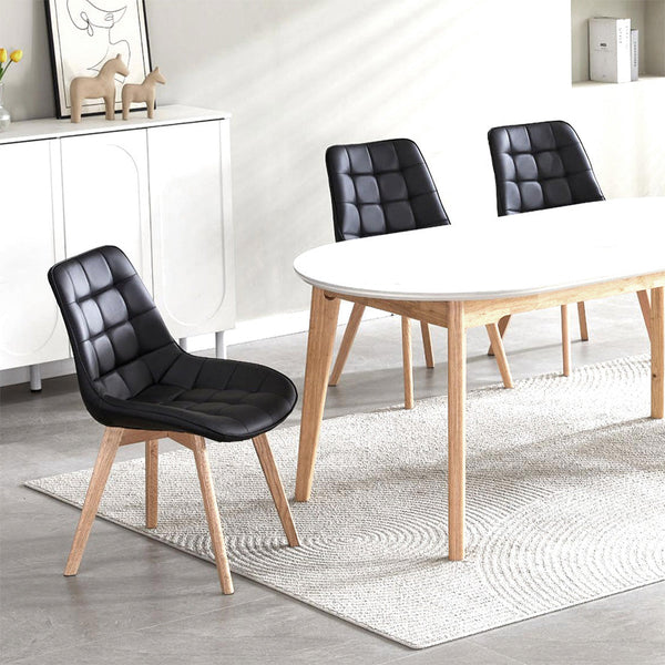 Black dining chair with quilted PU seat and back, and angled light wood legs