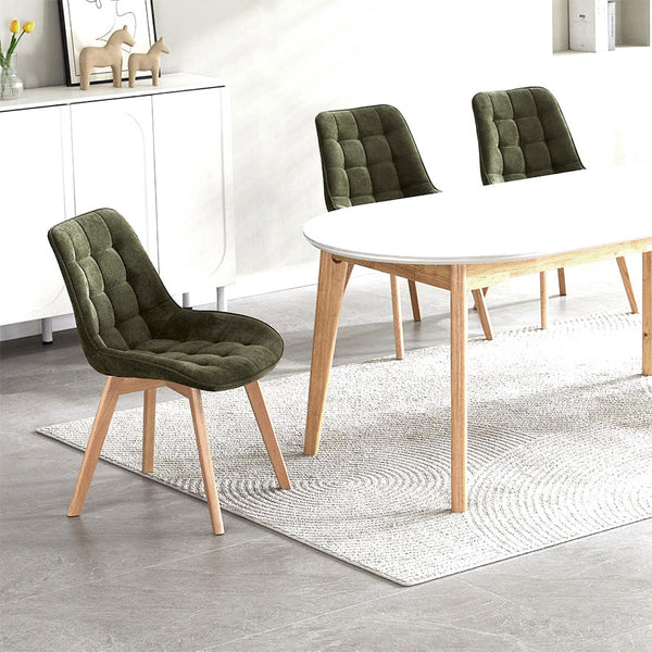 Dining room with green chairs and a white table on a gray floor.