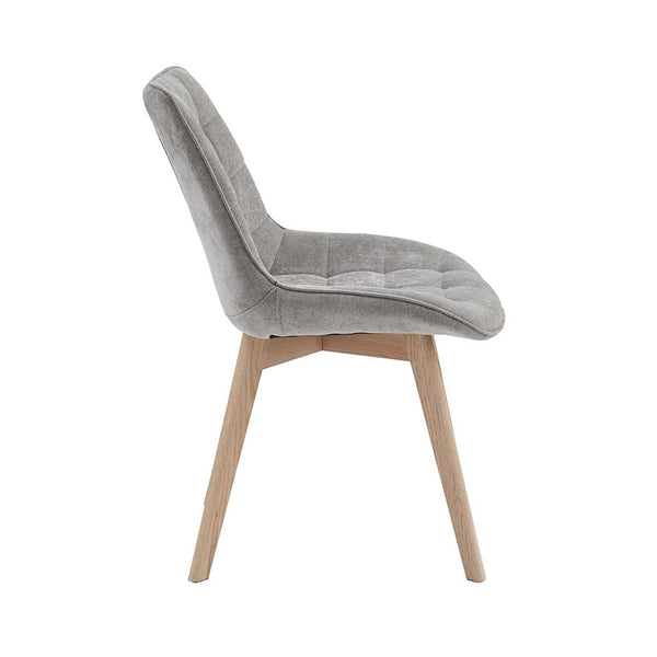Upholstered dining chair in light grey fabric with curved arms and angled wooden legs