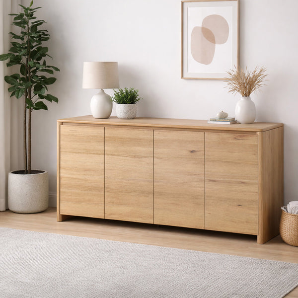 Wooden sideboard in a room with decor elements like a lamp, plants, and a rug.