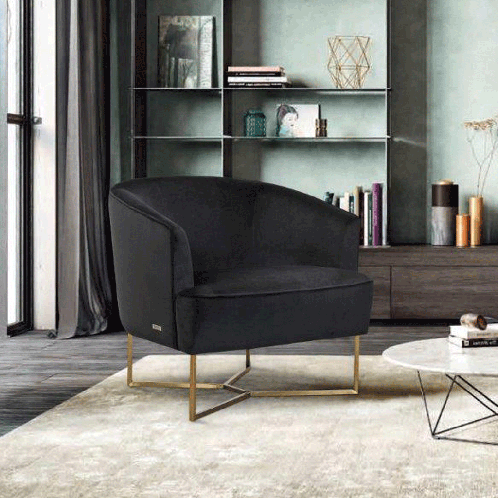 Black velvet accent chair with rounded arms and gold base, side view.