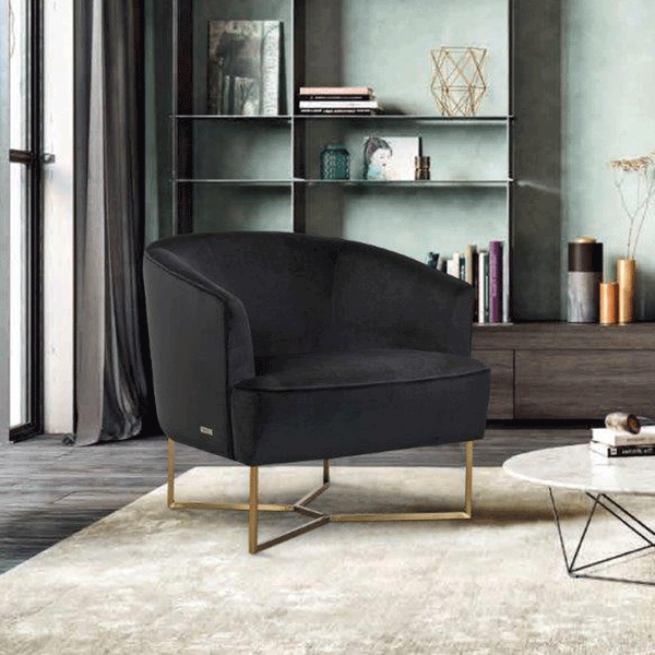 Black velvet accent chair with rounded arms and gold base, side view.