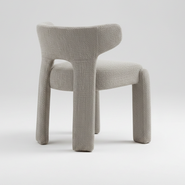 A modern upholstered accent chair with a rounded backrest and integrated armrests, upholstered in a textured bouclé fabric in a light taupe-gray color, shown from the rear on a white background.