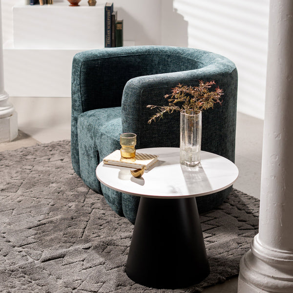 Round white side table with black pedestal base, styled with candles and decor