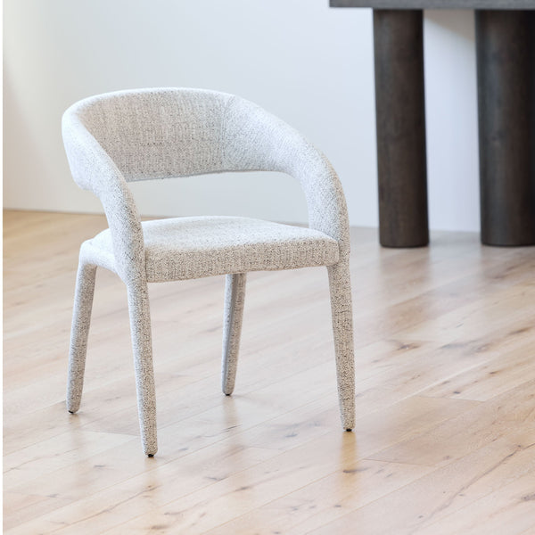 Seafoam dining chair with curved upholstered back, armrests, and tapered wooden legs