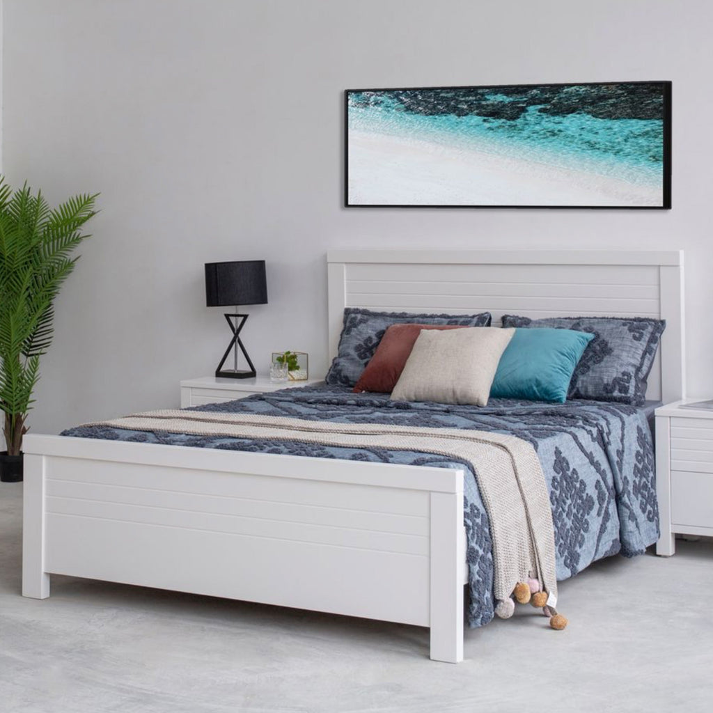 White wooden bed frame with slatted headboard and side drawer storage, viewed in room