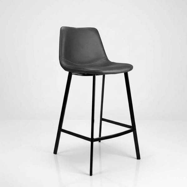 Antique black bar stool with padded vinyl seat, curved back, metal legs and footrest