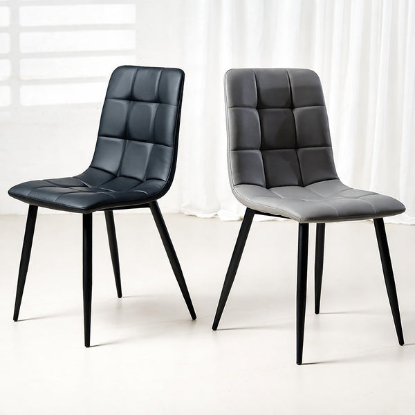 Pair of charcoal dining chairs with quilted upholstery, curved backs, and black legs