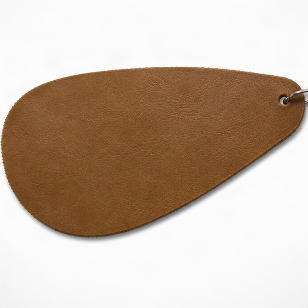 A teardrop-shaped brown leather accessory with a textured finish and a metal ring attachment, shown on a plain white background.