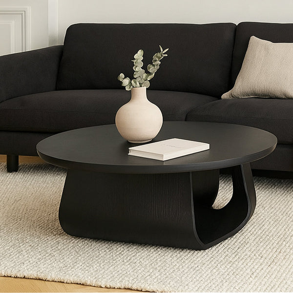 Round coffee table with dark finish, circular tabletop, sculpted pedestal base