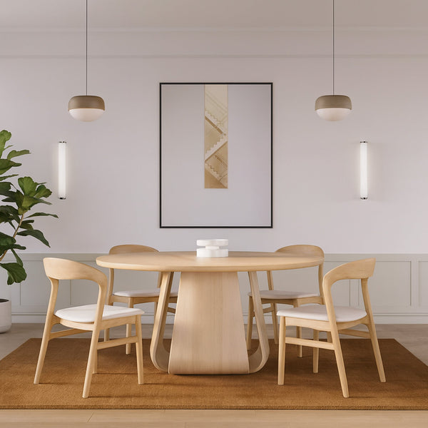 Round natural oak dining table with four matching willow chairs and light gray seats