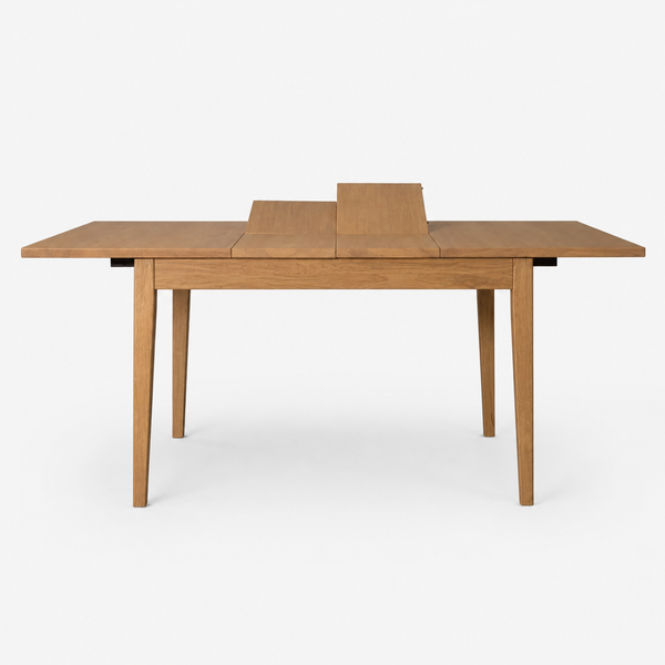 A light oak wood extendable dining table with a rectangular top, four tapered legs, and a central leaf extension mechanism, shown on a plain white studio background.