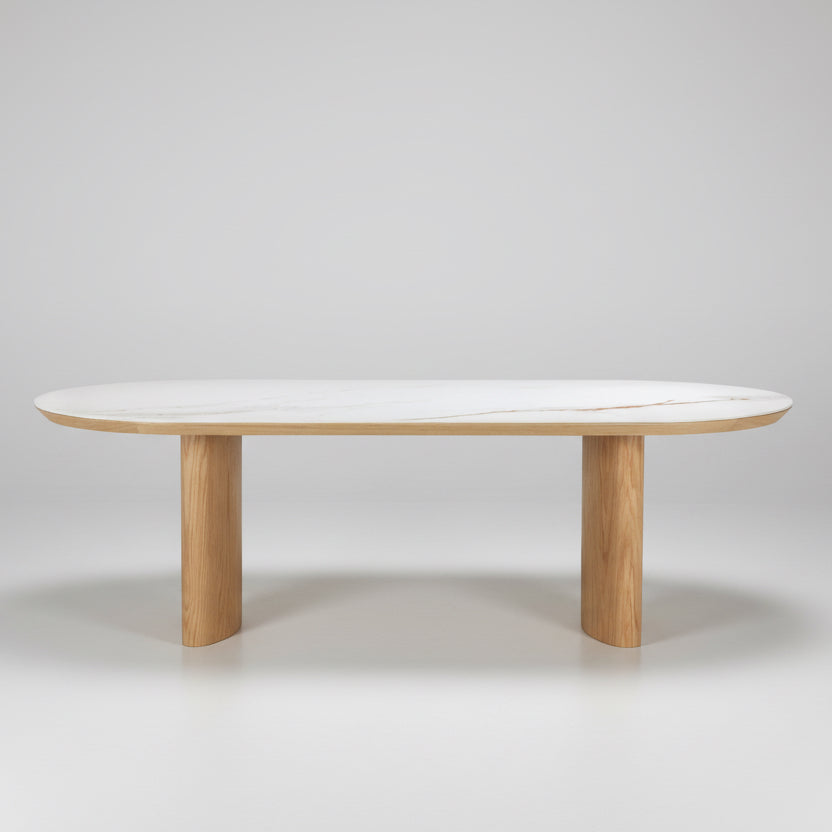 Round dining table with light white top and natural wood pedestal base