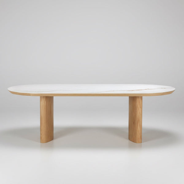 Round dining table with light white top and natural wood pedestal base