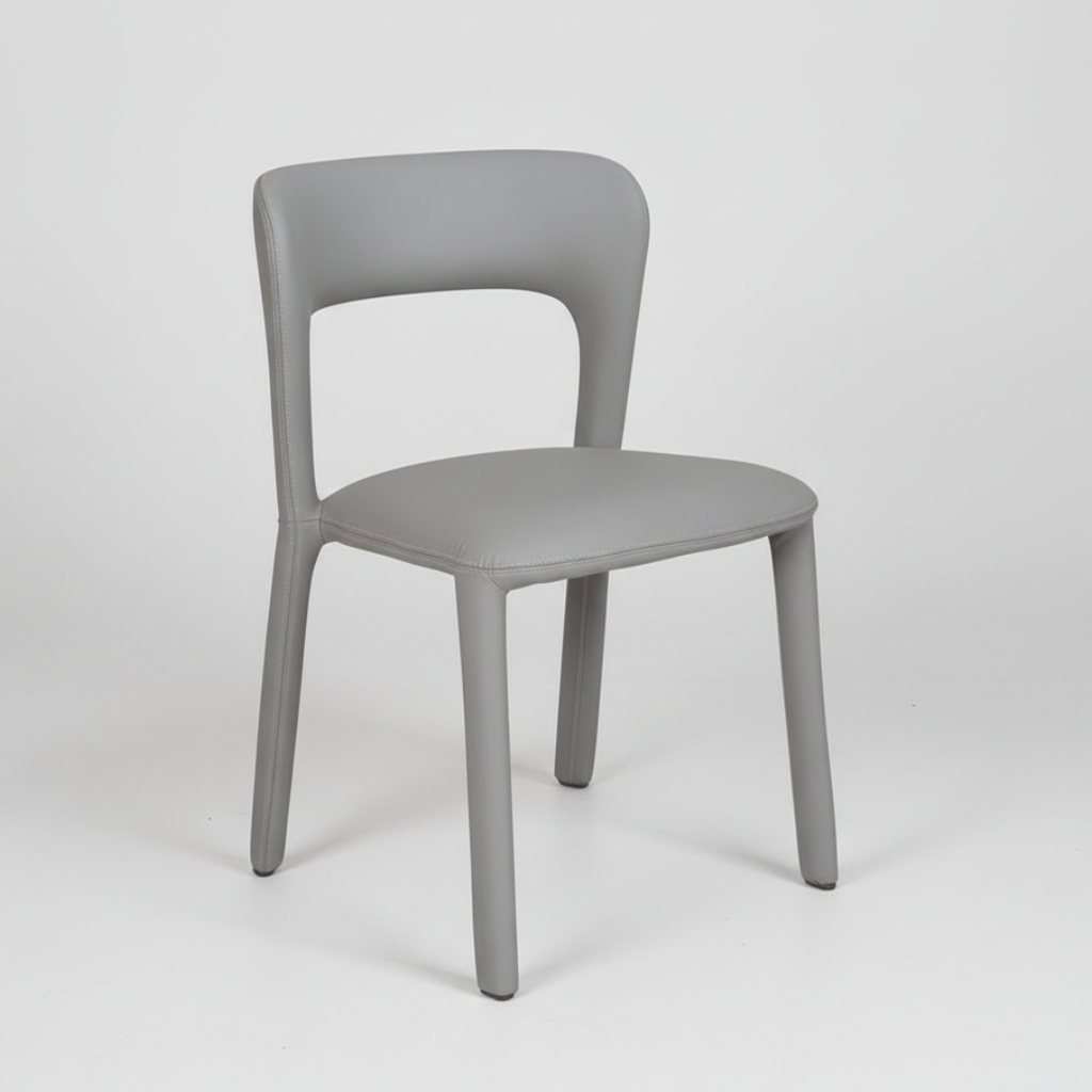 Grey upholstered dining chair with curved backrest and cushioned seat on four legs.