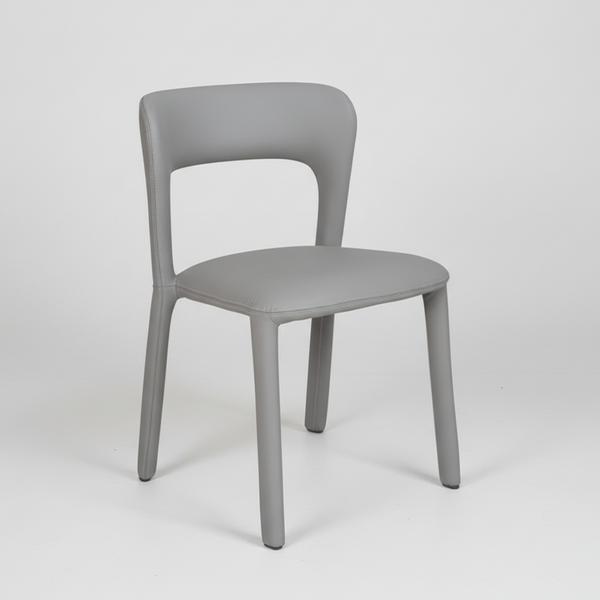 Grey upholstered dining chair with curved backrest and cushioned seat on four legs.