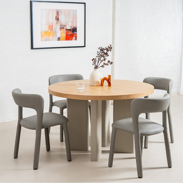 Grey upholstered dining chair in a set around a wooden table.