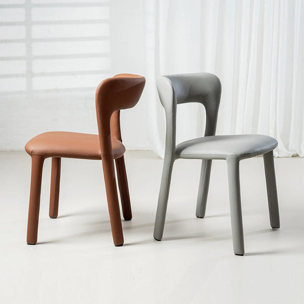 Tan dining chair with rounded back and seat, tapered wooden legs; paired with a light gray chair