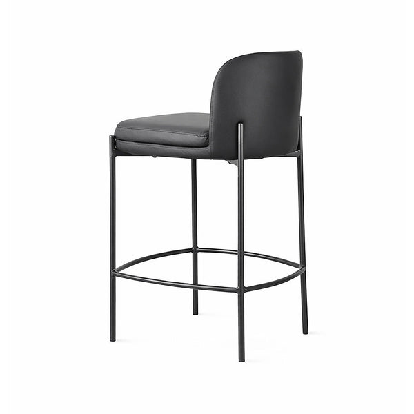 Black bar stool with curved backrest, padded seat, metal frame and circular footrest