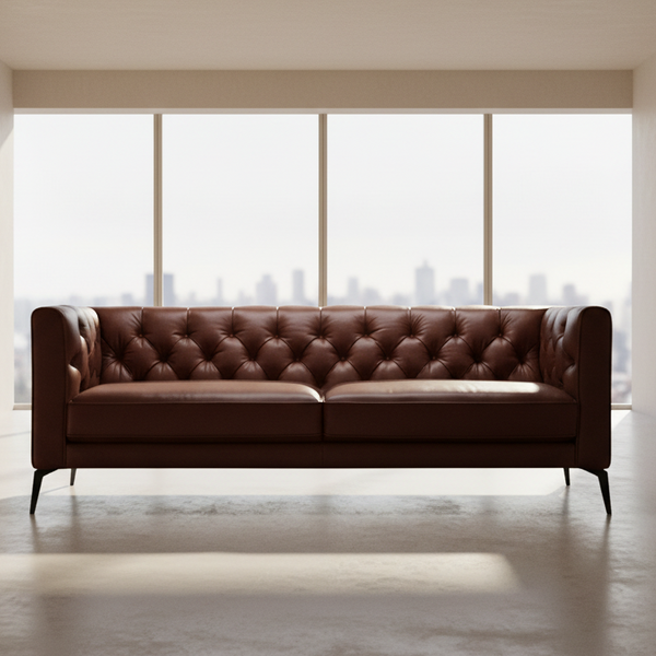 Brown leather Chesterfield sofa with button-tufted back and padded seat with low arms