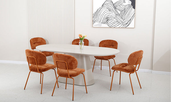 Brown fabric dining chairs with curved backs and metal legs, set around a table