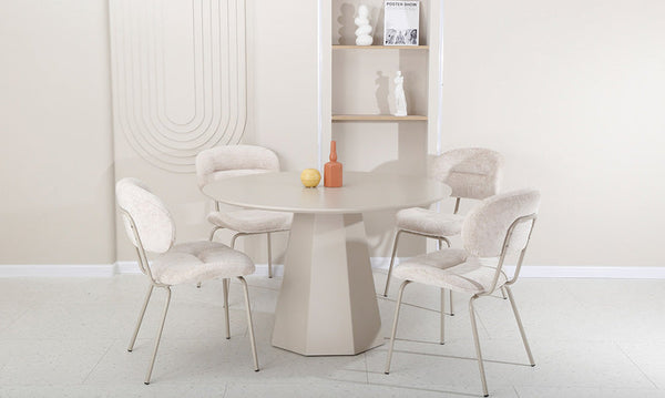 Pearl fabric dining chairs around a table, with curved padded backs and metal legs