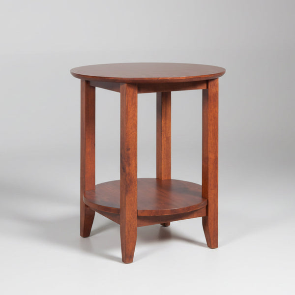 Wooden side table with a round top and shelf on a gray background