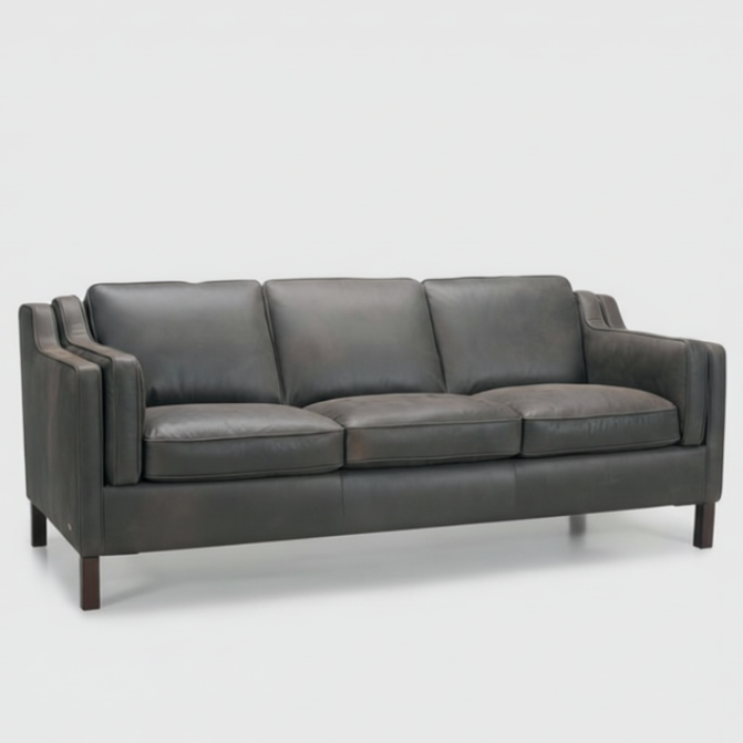 Dark gray leather sofa with three seat cushions and padded arms