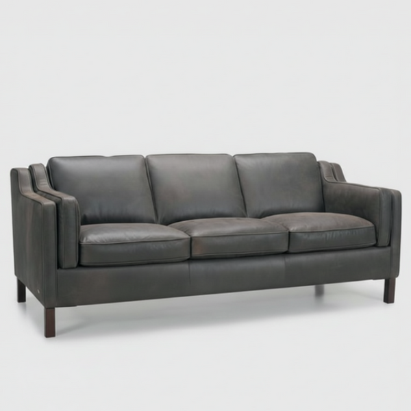 Dark gray leather sofa with three seat cushions and padded arms