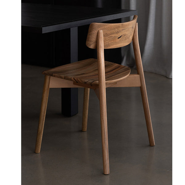 Wood dining chair with solid seat, curved back, and tapered legs
